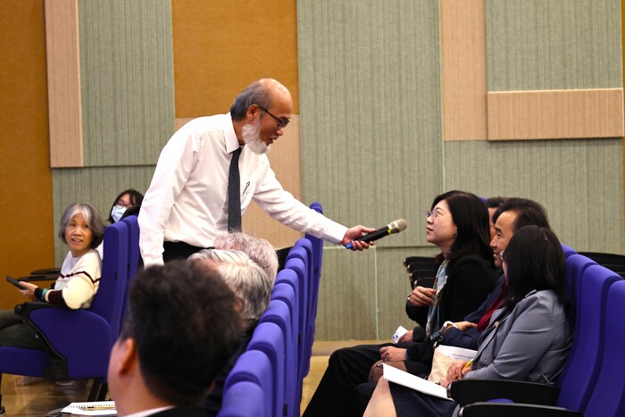 講者走入座席與與會者即時互動，透過提問與回應深化交流，現場討論氣氛熱烈。圖片