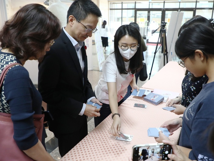 疾管署長羅一鈞(左二)和學生一起玩HIV生存戰卡牌。圖片