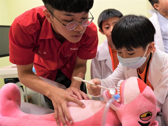 中山醫大志工用心準備教具，吸引國小學童專注學習。