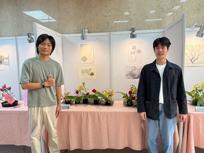 學生於自己的作品前合影，呈現通識課程藝術實作成果。圖片
