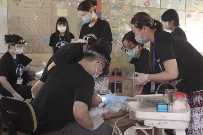 中山醫大義診團為柬埔寨當地居民及學童進行口腔檢查與牙科治療，提供專業醫療服務。圖片