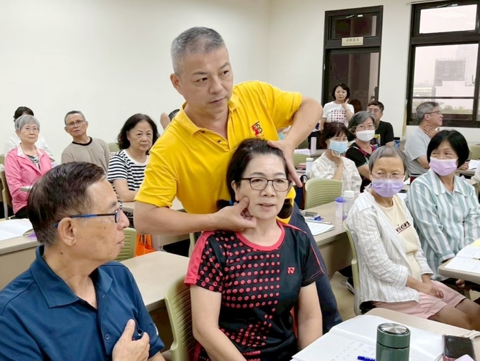 「經絡推拿」課程現場示範推拿技巧，學員近距離學習日常保健方法。圖片