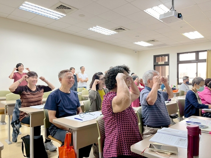 中山醫大樂齡大學課程帶領學員進行簡單物理治療動作，提升日常保健觀念。圖片