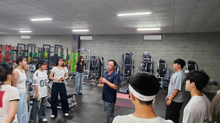 張誠崇帶領學生參觀球隊重量訓練室，介紹職業運動員體能培訓與表現提升策略。圖片