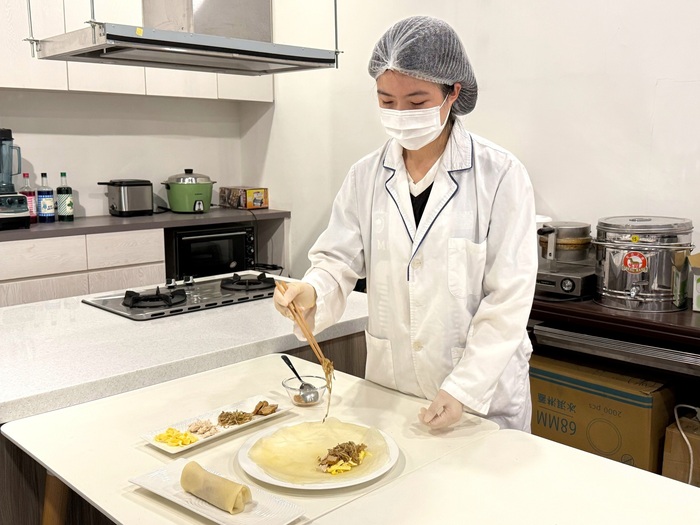 中山醫大營養系學生以雞胸肉、豆干、蛋皮及蔬菜製作潤餅內餡，強調高蛋白與均衡營養。圖片